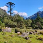 A Valley with mountains on both sides and a lot of rocks and clouds moving above them.