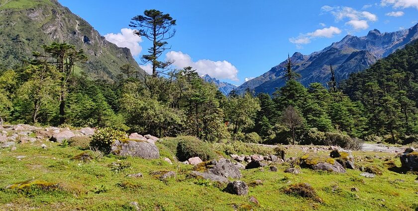 A Valley with mountains on both sides and a lot of rocks and clouds moving above them.