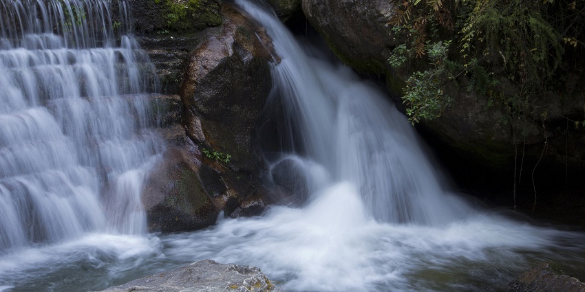 Picturesque view of a waterfall cascading through big rocks - picnic places to visit in Ahmedabad