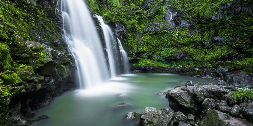 Image of waterfall in a dense forest water caseding through rocks and river