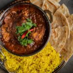 A vibrant bowl of curry rice served with warm pita bread -best food in Chandni Chowk