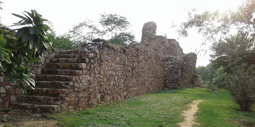 A picture of a stairway at a fort made in the traditional style with a garden area near the stairs
