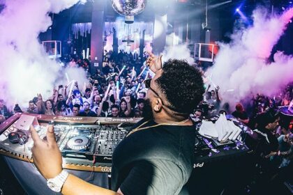 A picture of a night club in Goa with a DJ playing party songs and crowd enjoying the music