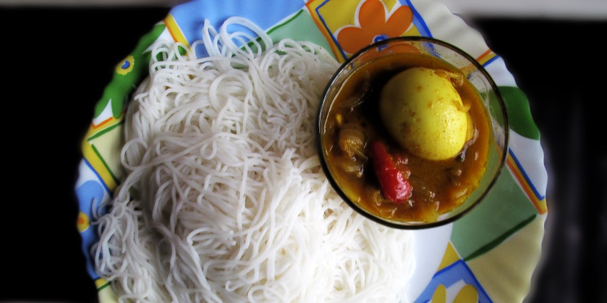 Idiyappam served with rich egg curry, showcasing a traditional South Indian meal.