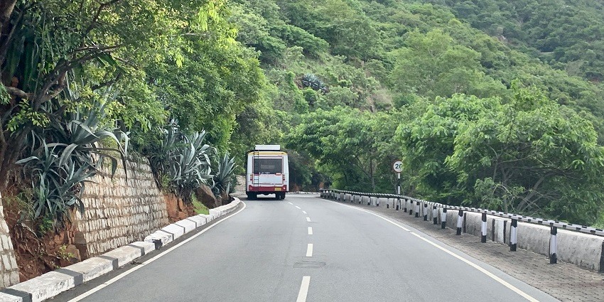 A highway surrounded by lush greenery in Andhra Pradesh, passing by the temple village