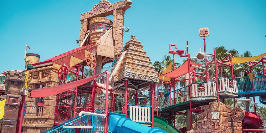 A stunning aerial view of assorted water slides with a pool in front during the daytime.