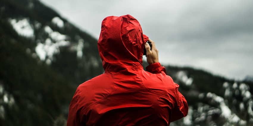 A picture of a traveller taking a picture of the landscapes in front of him