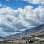 A breathtaking view of a valley in Ladakh with snow-covered mountains during the day.