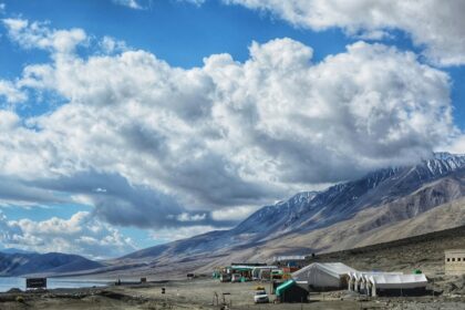 A breathtaking view of a valley in Ladakh with snow-covered mountains during the day.