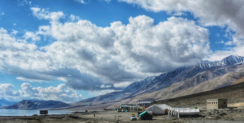 A breathtaking view of a valley in Ladakh with snow-covered mountains during the day.