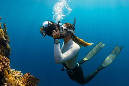 A breathtaking view of a woman enjoying an underwater activity surrounded by corals.