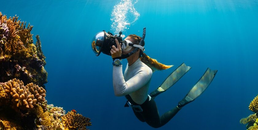 A breathtaking view of a woman enjoying an underwater activity surrounded by corals.