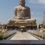 Visitors pose for a photo near the Great Buddha Statue in Tergar Monastery.