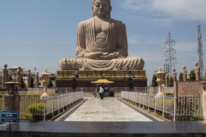 Visitors pose for a photo near the Great Buddha Statue in Tergar Monastery.