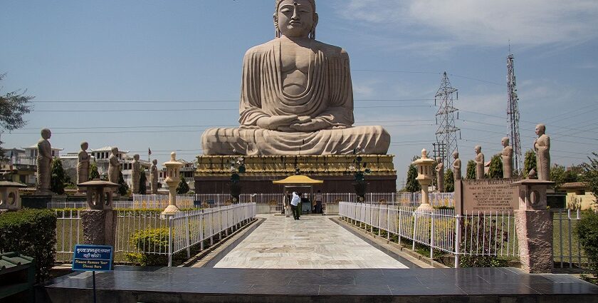 Visitors pose for a photo near the Great Buddha Statue in Tergar Monastery.