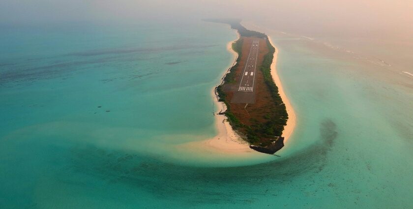 A breathtaking view of a lush green island surrounded by turquoise waters on all sides.