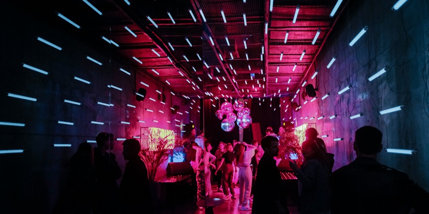 An inside view of the famous AER rooftop bar featuring dazzling neon lights and more.
