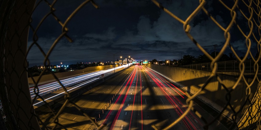 An image of a dark, lonely stretch of AH 43 which is illuminated by headlights.