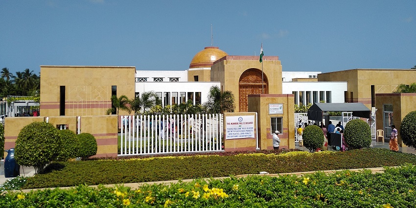 A frontal view of a historic memorial with a lush green garden area in front of it