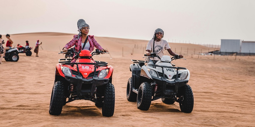 A picture of people enjoying a thrilling ride on an ATV across rocky terrain.