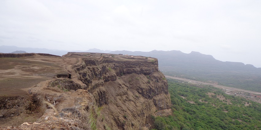 A scenic picture of Aamby Valley with the lush greenery and a lake surrounding it.
