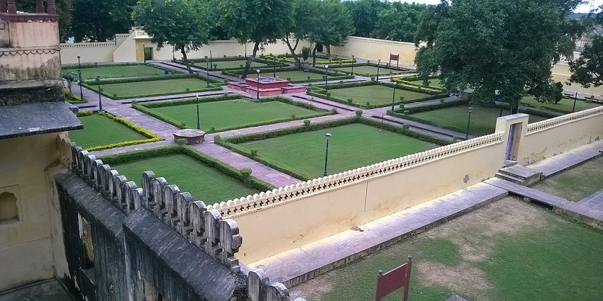 Tranquil view of Abheda Mahal's park, featuring lush lawns and a serene garden.