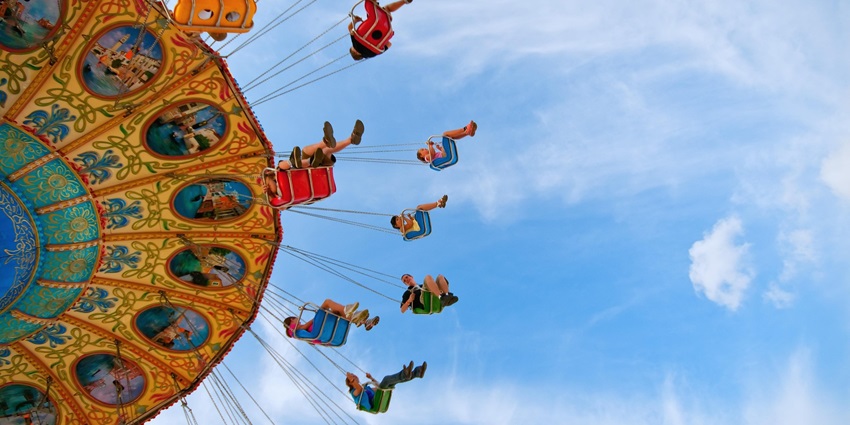 Colorful theme park with rides and attractions under a clear blue sky.