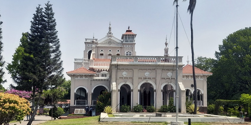 A picture of a beautiful palace surrounded by a lush garden and trees
