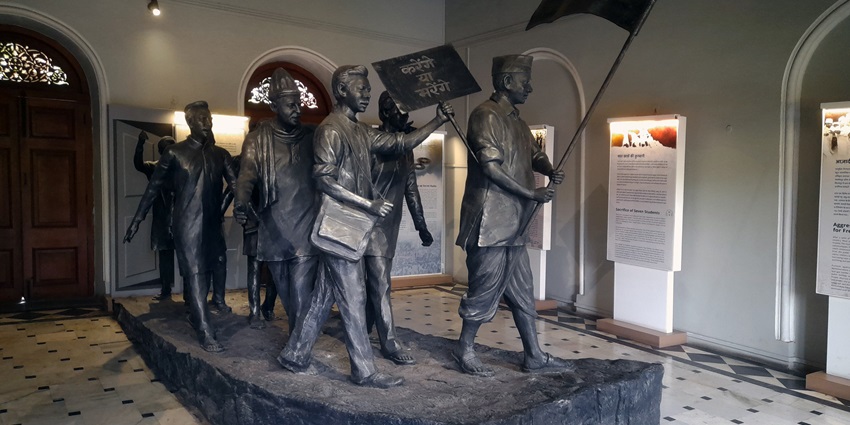 A historical inside view of Aga Khan Palace, having six sculptures standing on one big stone