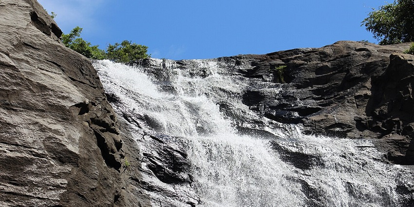 A majestic view of a stunning waterfall amidst lush greenery, perfect for nature lovers.