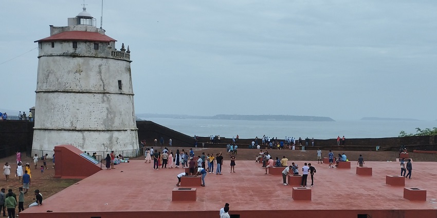 A glimpse of the towering lighthouse at the iconic Fort Aguada, a tourist destination.