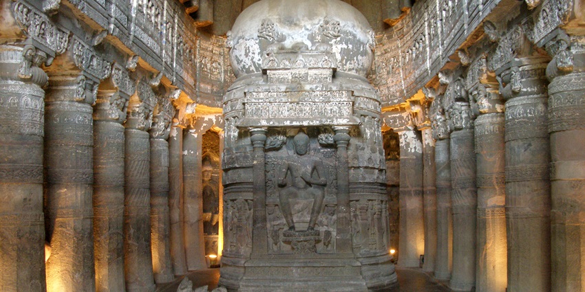 A picture of the scenic interiors of Ajanta Caves with intricate carvings and statues all around