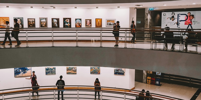Multiple modern art paintings stuck on the walls of this art gallery.