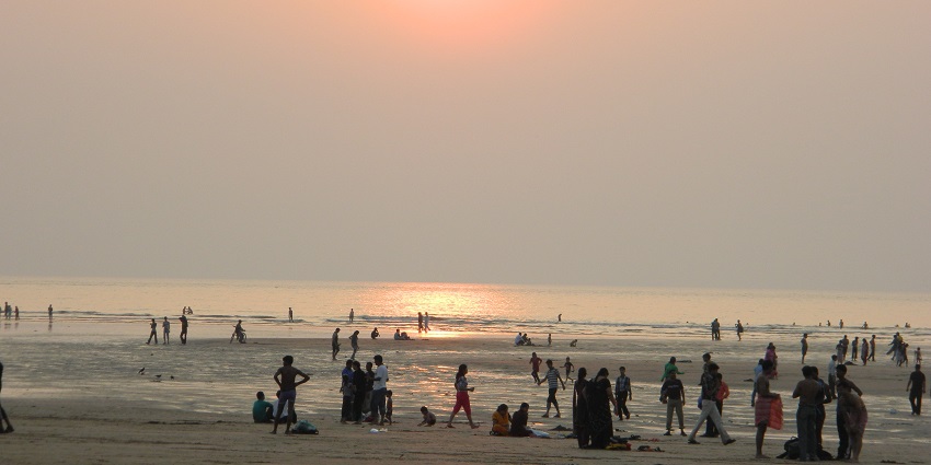 Tourists enjoying the afternoon sunset at crowded Aksa Beach, offering kayaking in Mumbai.