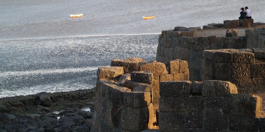 A picture of the historical Alibaug Fort with serene views of the sea in the background
