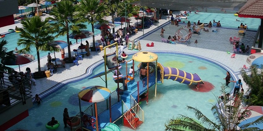Image of a water park people enjoying the slides and pool with family and friends