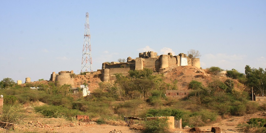 A distant view of the Amargarh Fort situated on the top of a hill surrounded by bushes