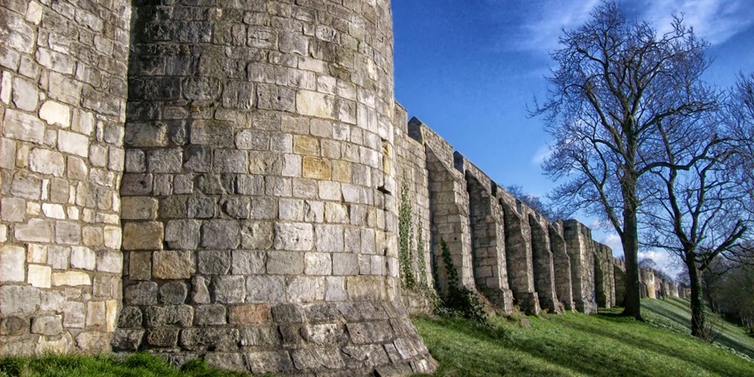 Explore the ancient stone walls of Ambagarh Fort standing on a green hilltop.