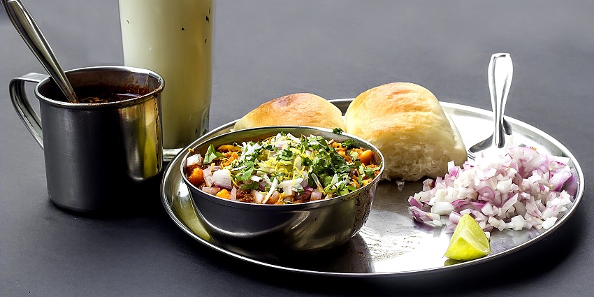 Misal Pav, a Maharashtrian delicacy served with chopped onions, lemon wedge and buttermilk