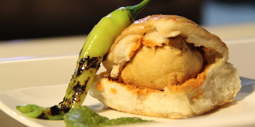 A street food in Andheri - Vada pav, stuffed with a potato vada and green chutney.