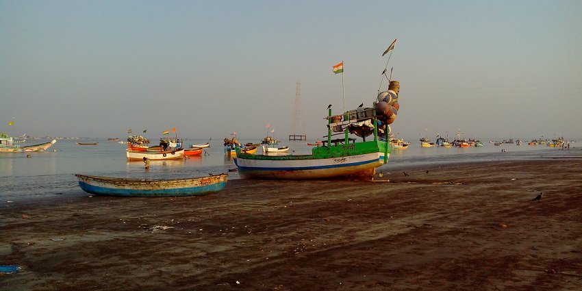 Beach with boats kept and a gorgeous backdrop.