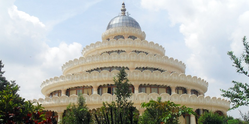 A serene spiritual retreat with a grand meditation hall and lush greenery, one of the best places to visit near Bannerghatta National Park.