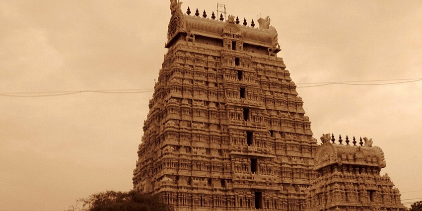 Majestic Arunachaleswarar Temple with towering gopurams against a vibrant sunset sky
