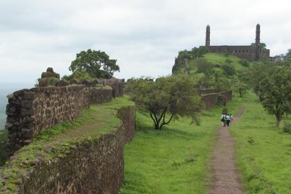 Image of a fort ruins surrounded by lush greenery under clear blue sky