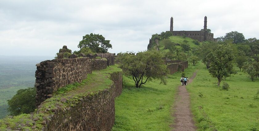 Image of a fort ruins surrounded by lush greenery under clear blue sky