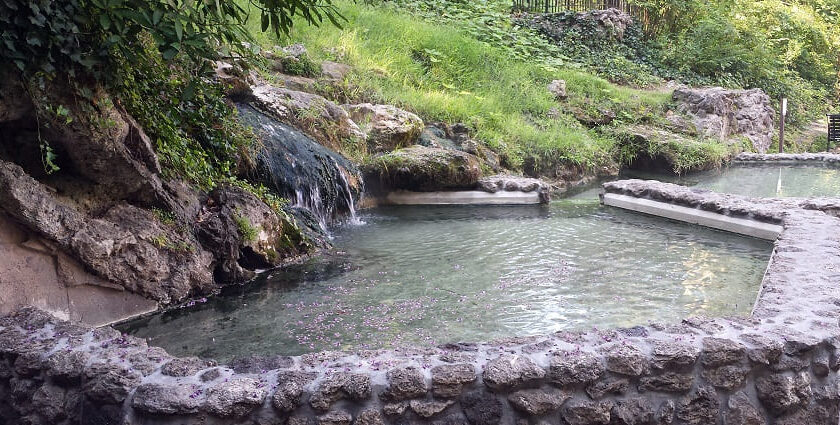 Scenic snap of the Atri Hot Spring surrounded by the beautiful complex and lush hill