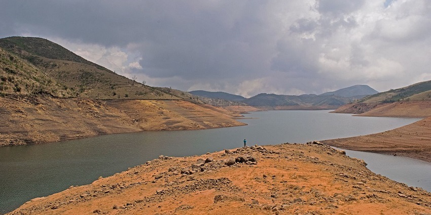 Places to visit near Ooty feature lake surrounded by lush greenery and stunning mountains.