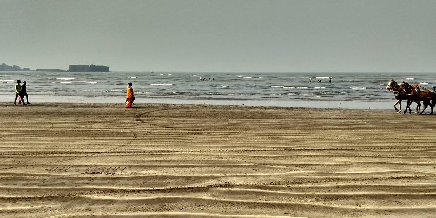 Awas Beach features serene golden sands and crystal-clear waters at sunset.