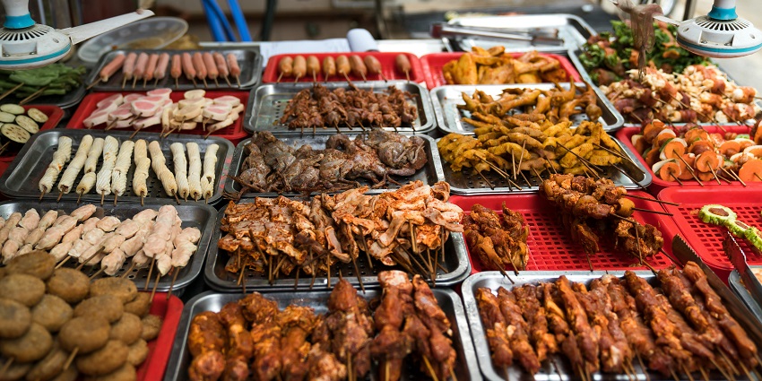 Different varieties of kebabs on display and served on silver plates at a local stall