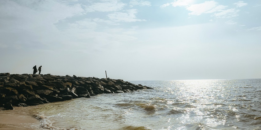 An image of the serene Baada Beach, warm hues glow on the tranquil ocean waves.